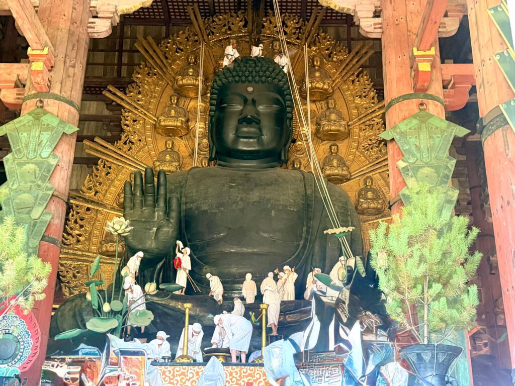 お身拭いで大仏さまの上に乗る白衣の人たち